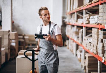 Young man working at a warehouse with boxes