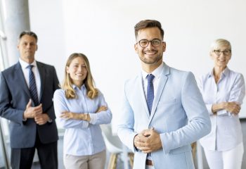 Group of a businesspeople standing together in the office with their young bussines leader