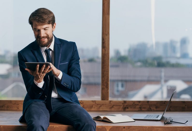 A man in a suit with a tablet in the hands of an office official, a professional businessmen. High quality photo