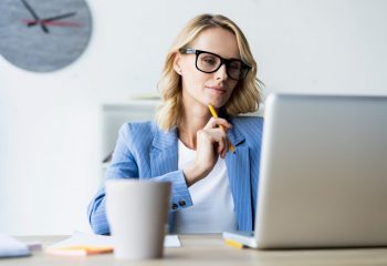 Portrait of a serious businesswoman using laptop in bright modern office